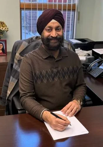 KJ Sikka Image sitting on his desk